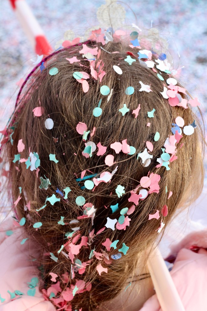 The hair of a young child covered in confetti. 