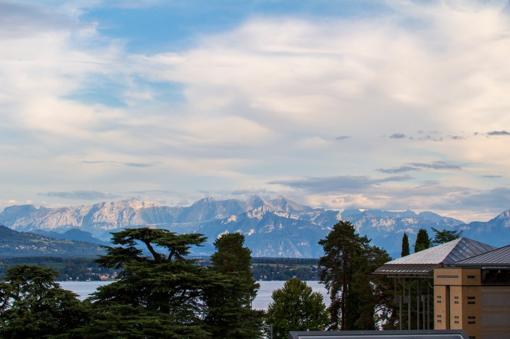 Panoramic view of Lac Leman, the French Alpine range and fir trees near the elementary school in Tannay. 
